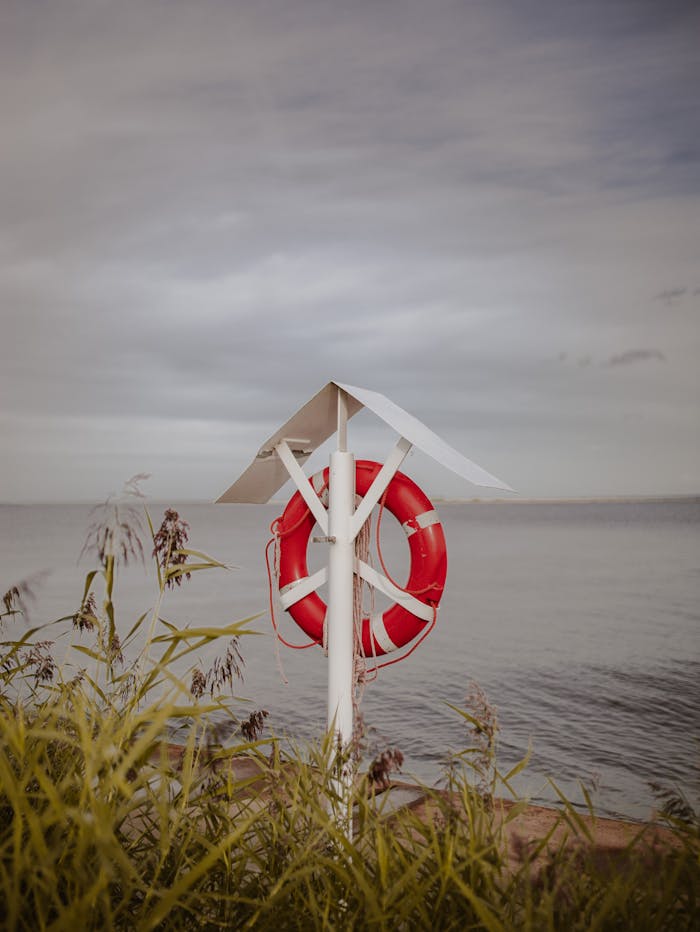 Lifebuoy box on sandy beach on overcast day
